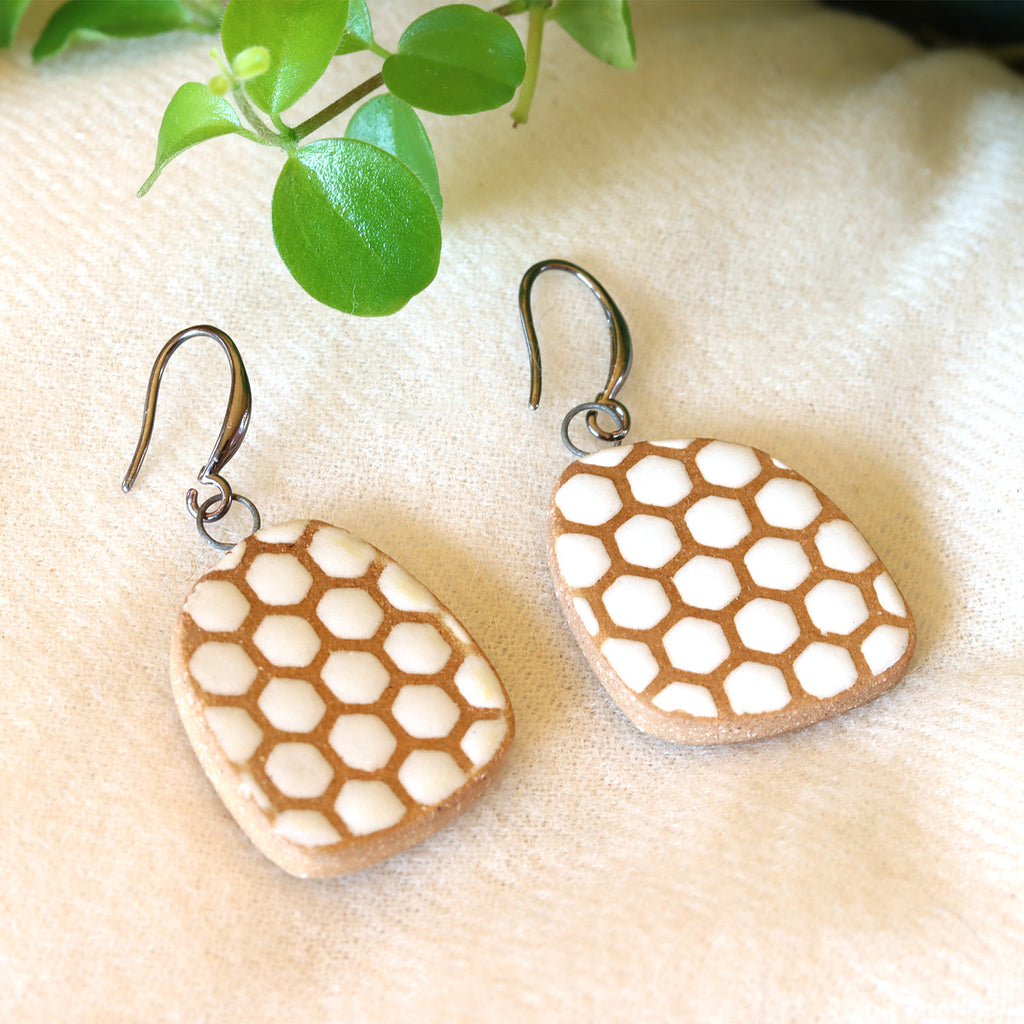 Handmade ceramic earrings with white beehive pattern