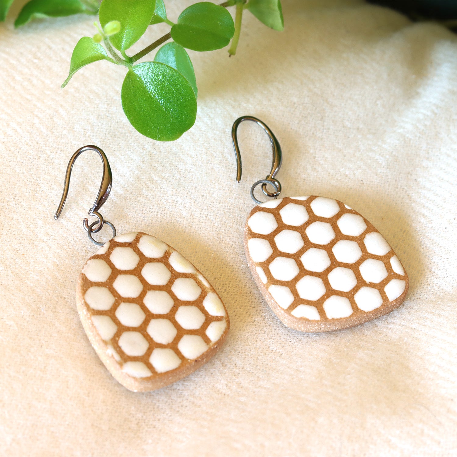 Handmade ceramic earrings with white beehive pattern