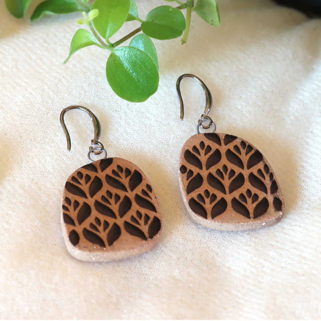Handmade ceramic earrings with black flower pattern