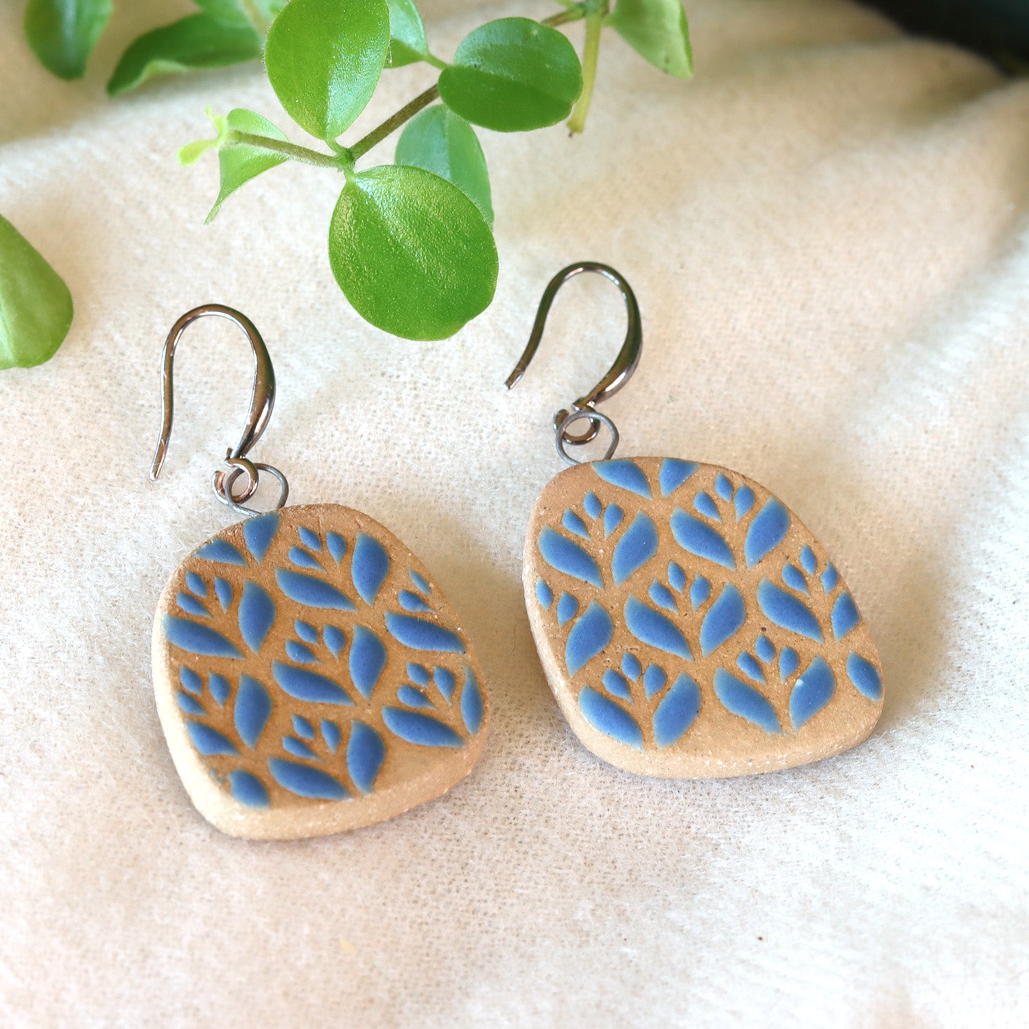 Handmade ceramic earrings with blue flower pattern