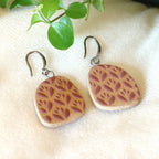 Handmade ceramic earrings with purple flower pattern