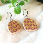 Handmade ceramic earrings with purple flowered pattern