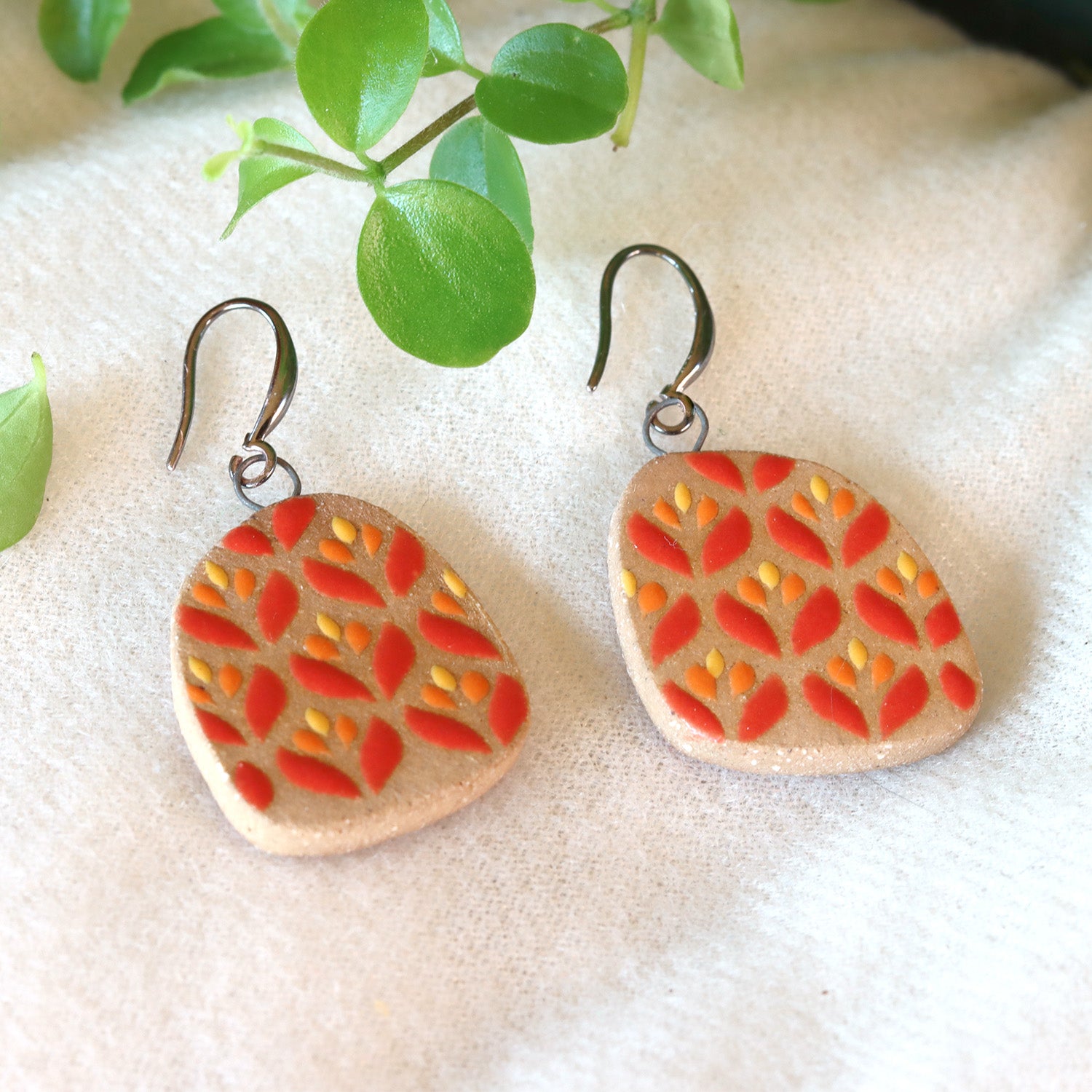 Handmade ceramic earrings with colored flower pattern