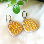 Handmade ceramic earrings with yellow flower pattern