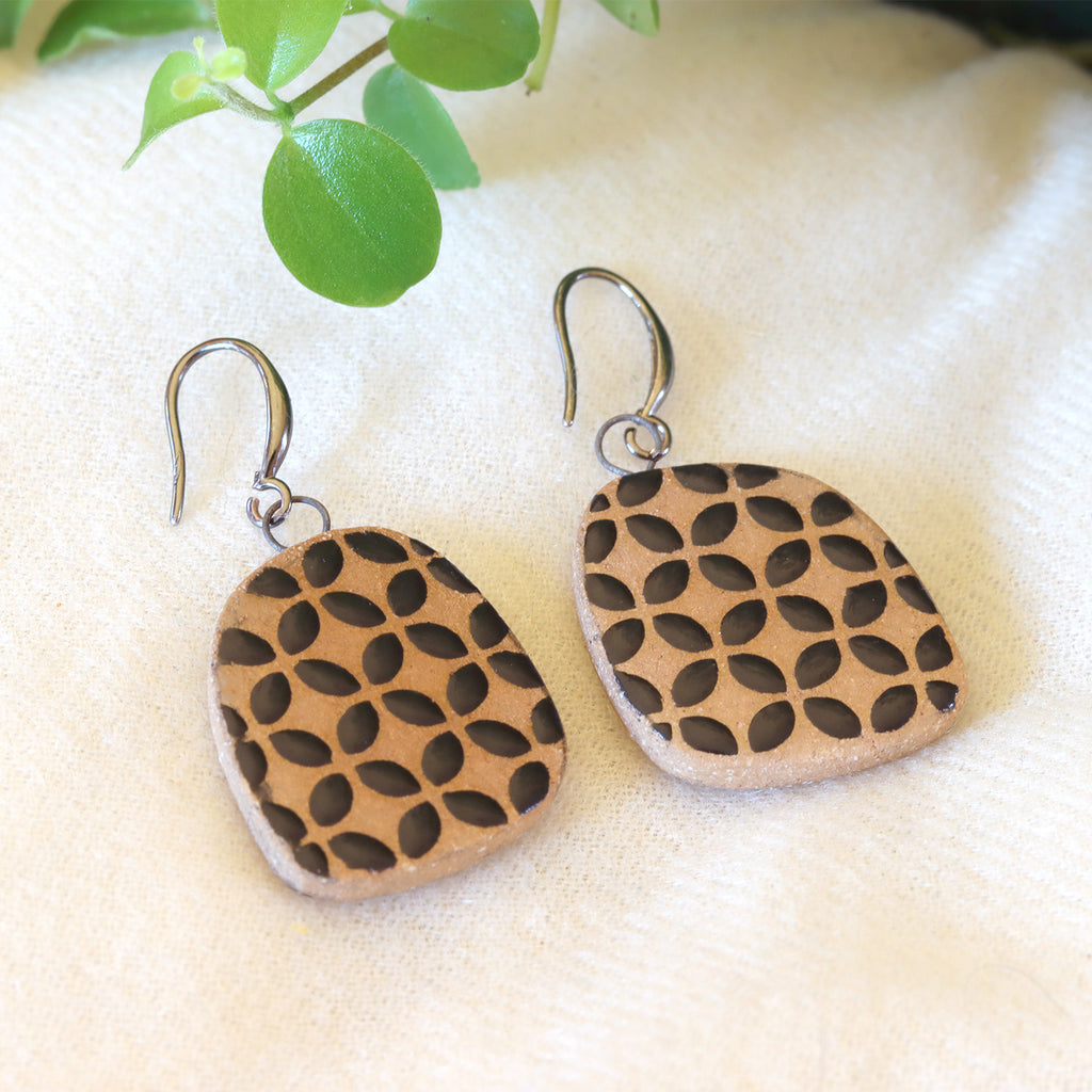 Handmade ceramic earrings with geometrical black pattern
