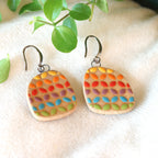 Handmade ceramic earrings with geometric rainbow pattern