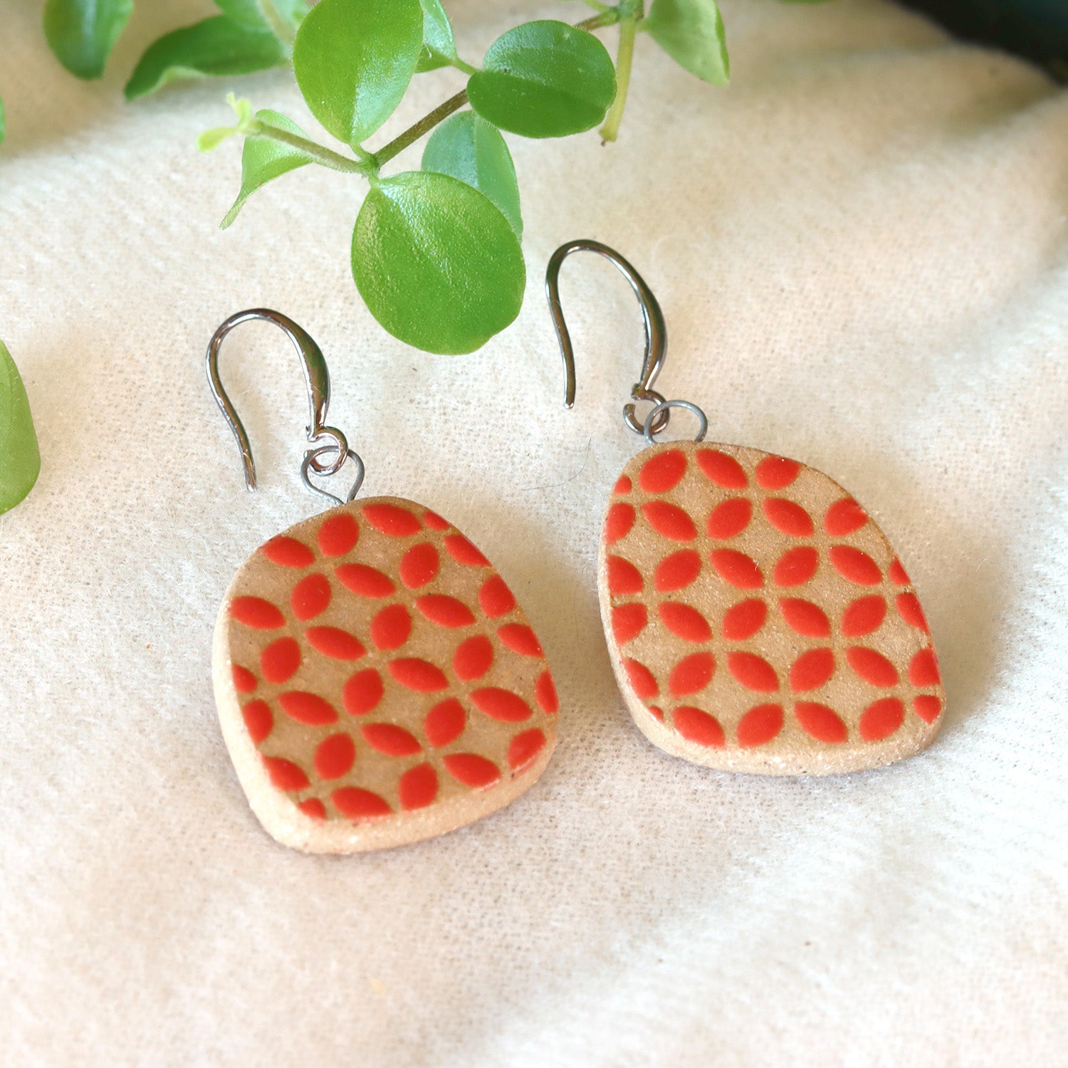 Handmade ceramic earrings with red geometric pattern