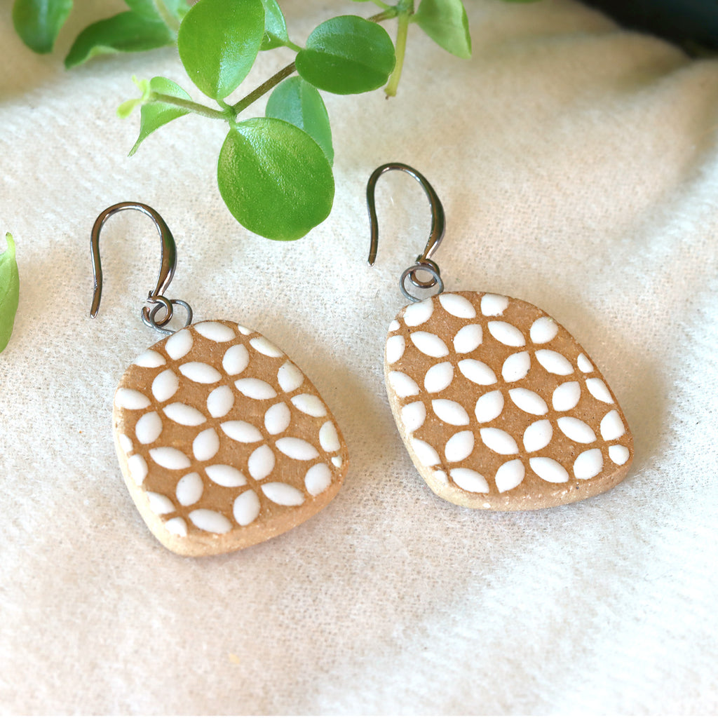 Handmade ceramic earrings with white geometric pattern