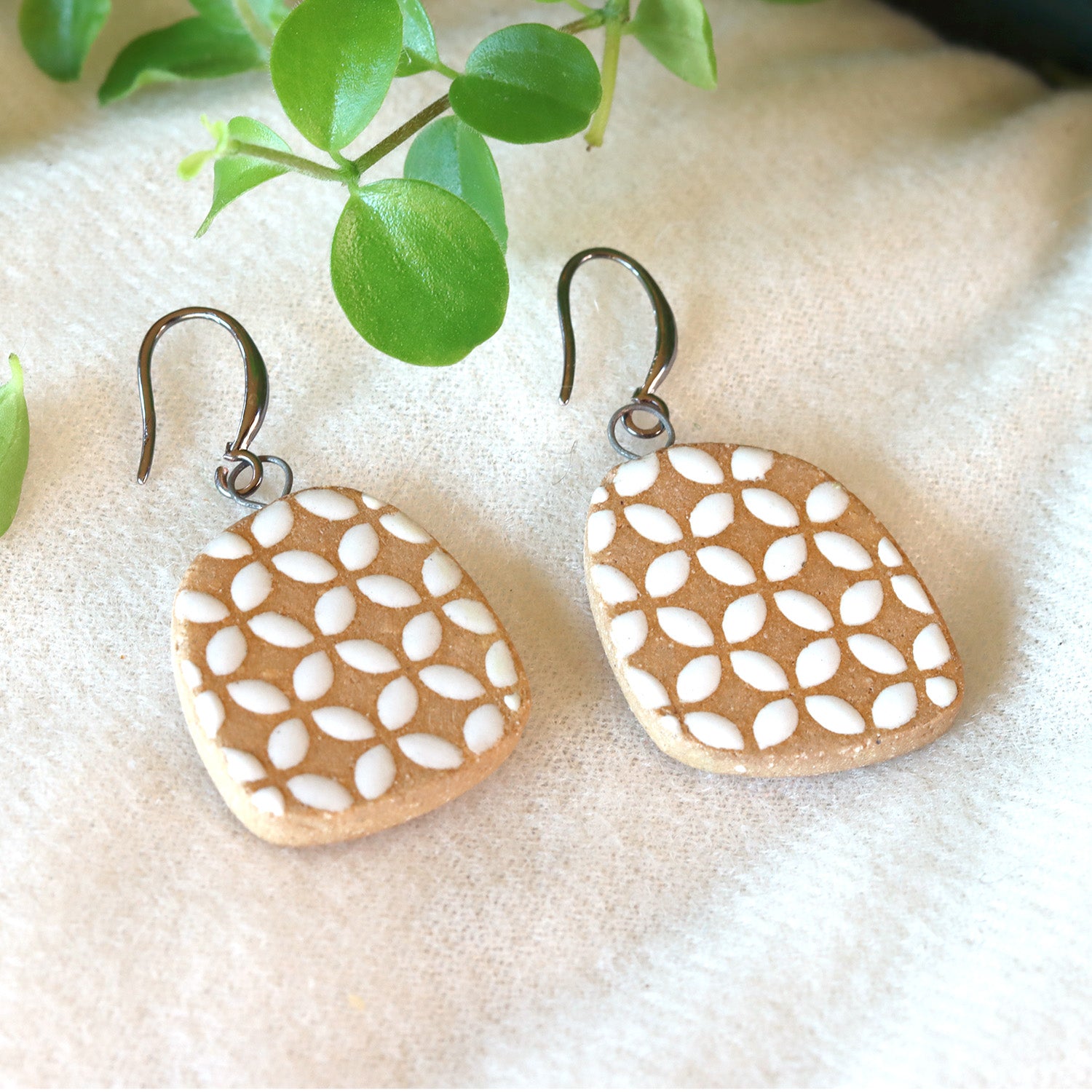 Handmade ceramic earrings with white geometric pattern