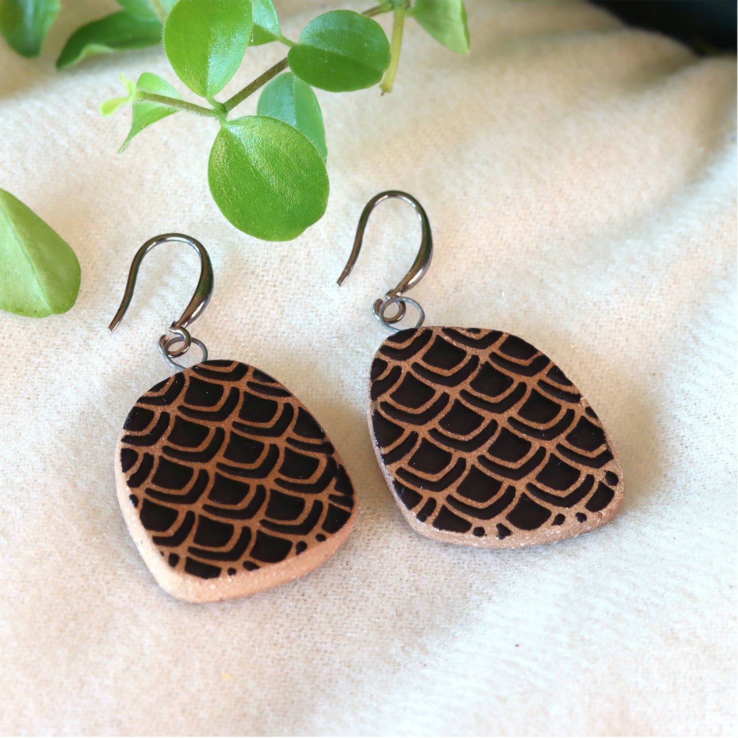 Handmade ceramic earrings with black petal pattern