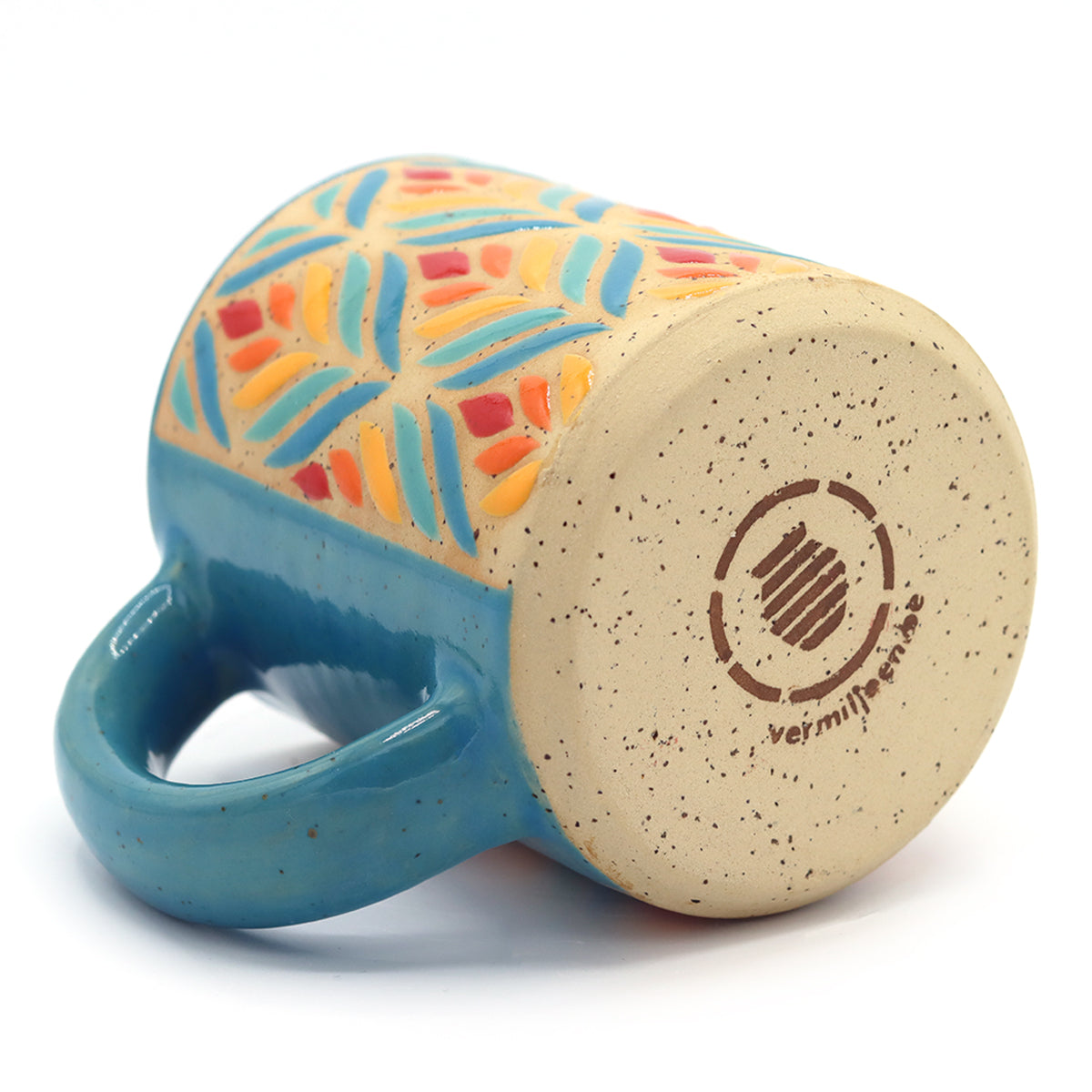 handmade ceramic mug with floral pattern in vibrant colours. 