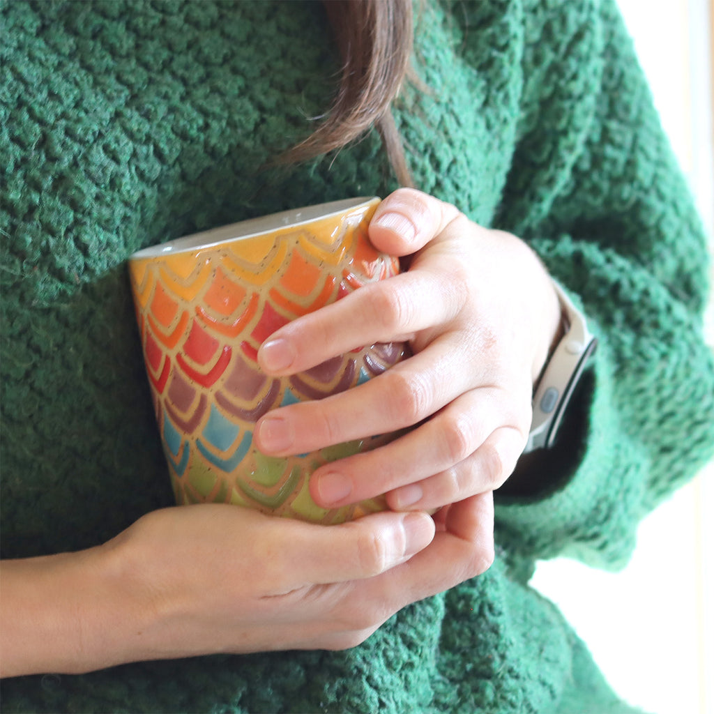 handmade stoneware coffeemug in geometric rainbow pattern with petals